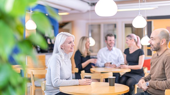 medarbetare som tar en kaffe och skrattar