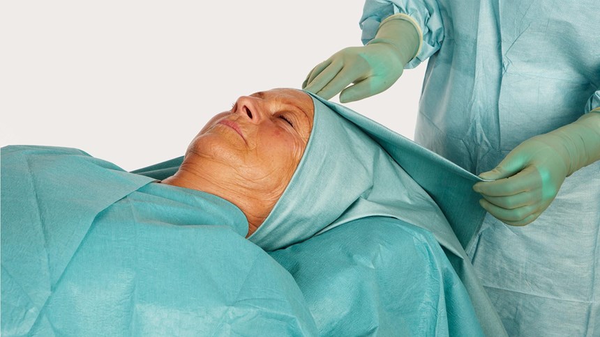 en kvinnlig patients huvud draperat i barrier ent-lakan