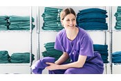 sjuksköterska i BARRIER avdelningskläder sitter i ett omklädningsrum