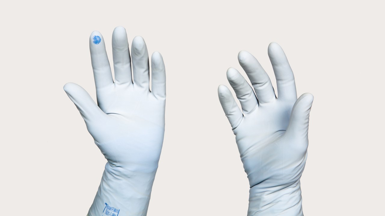 deux mains portant des gants avec système d'indication des perforations Biogel